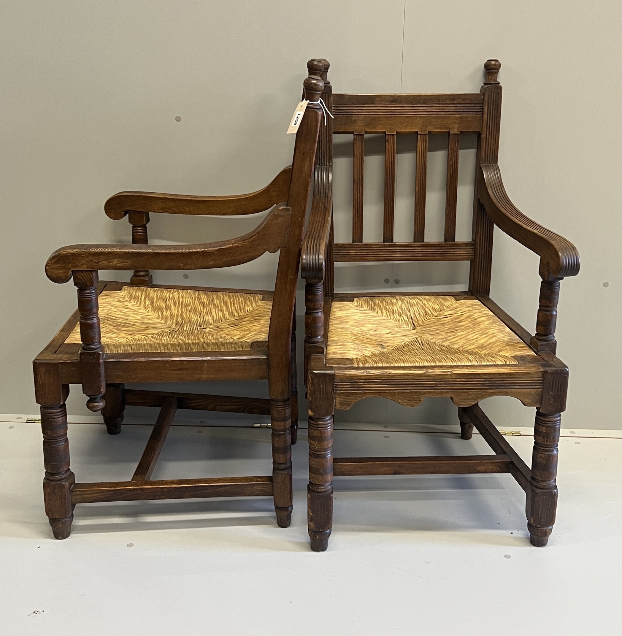 A pair of Victorian Arts & Crafts oak rush seat elbow chairs, width 58cm, depth 54cm, height 104cm